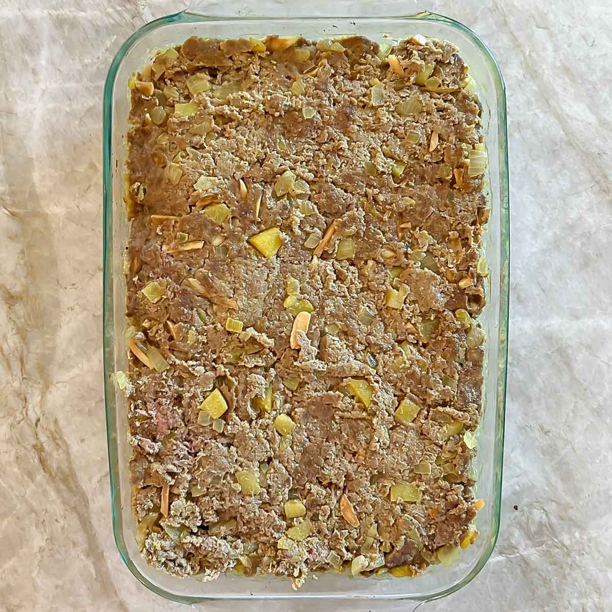 Bobotie after first round of baking, repacked into baking dish