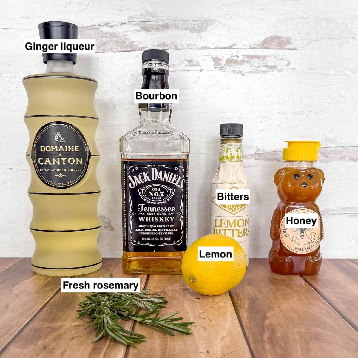 The ingredients needed to make a lemon whiskey cocktail, lined up and labeled.