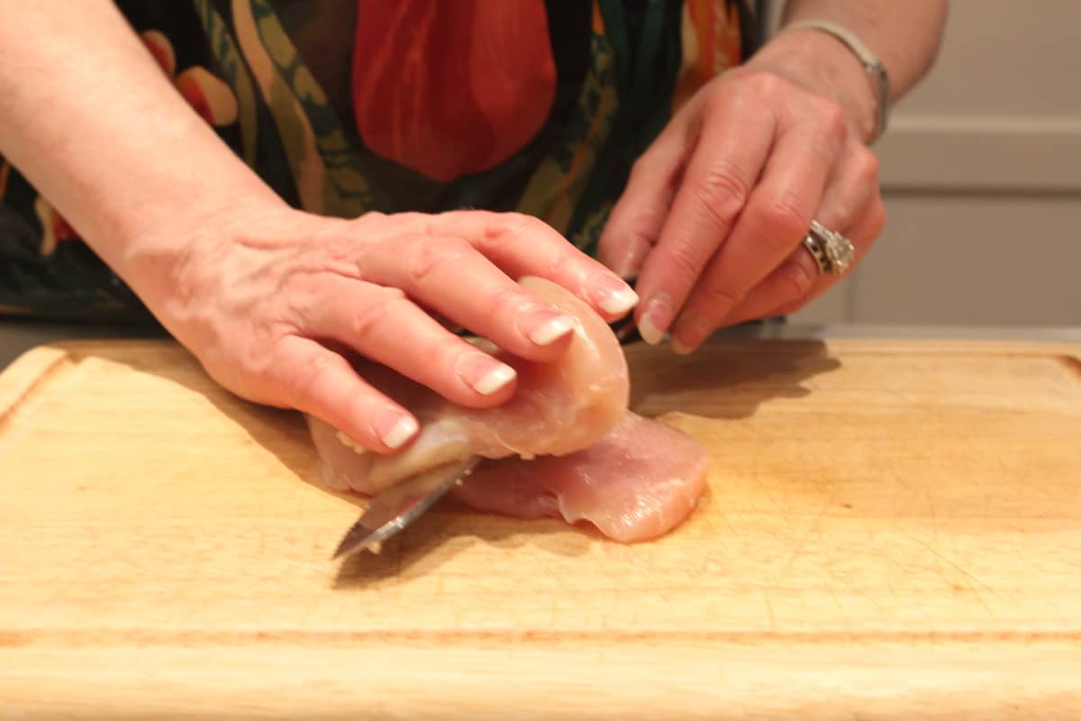 photo of hands showing step 2 of butterflying a chicken breast