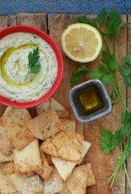 bowl of Cannellini Dip with Truffle Oil on a board with pita chips