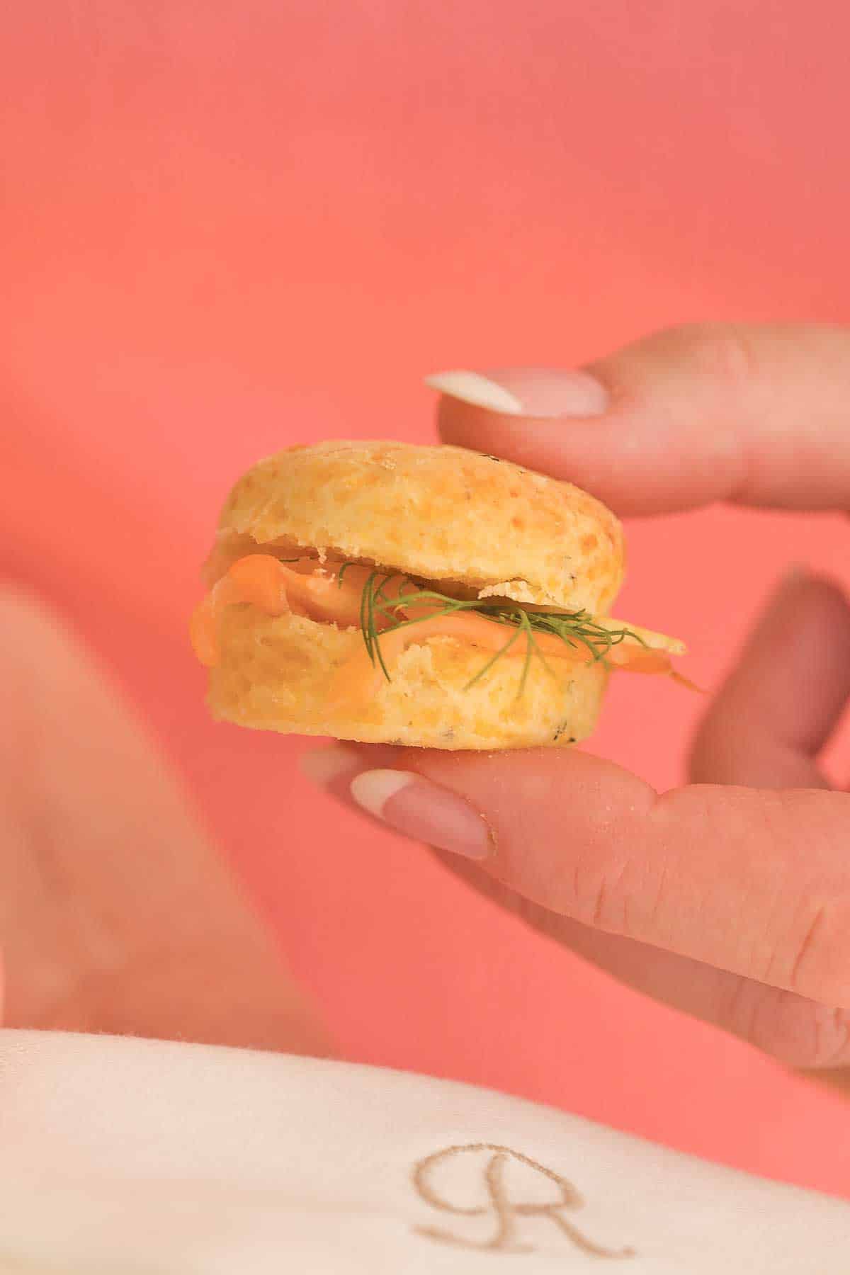 hand holding one Mini Cheddar Dill Scone; photo illustrates size of scone.