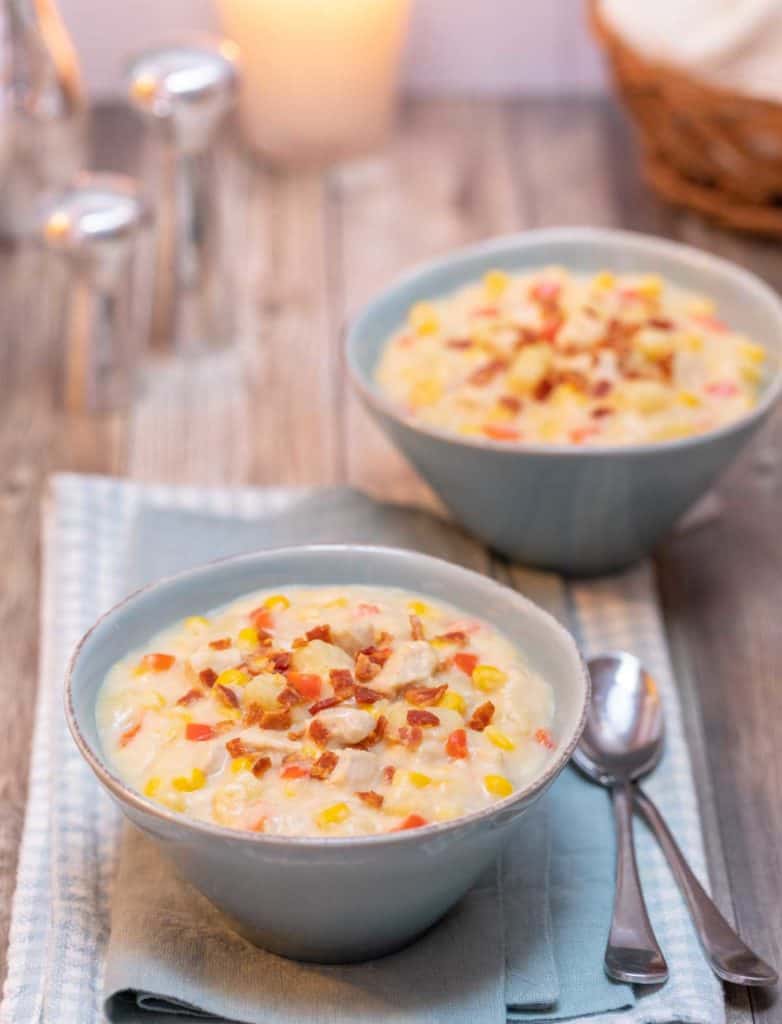 two light blue bowls filled with portions of Corn and Chicken Chowder