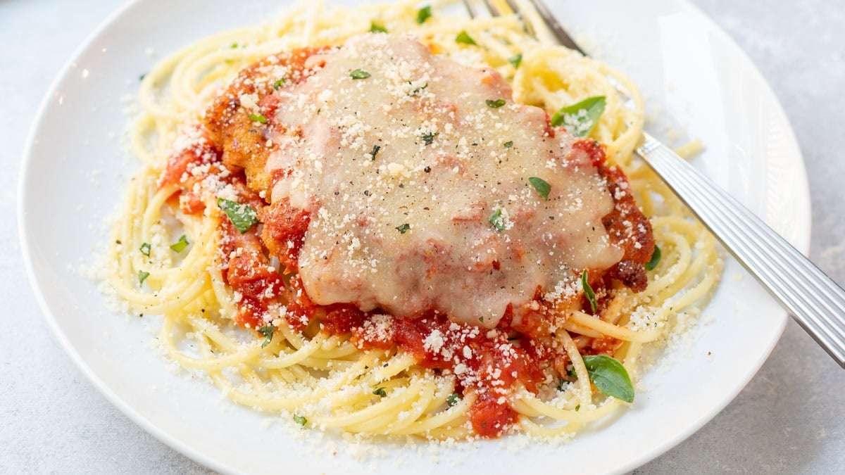 Close up photo of plated and garnished chicken parmesan.