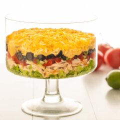 side view of a trifle dish filled with Shredded Chicken Taco Salad, with the ingredients arranged in layers