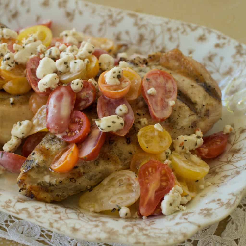 Grilled chicken breasts with cherry tomatoes and goat cheese