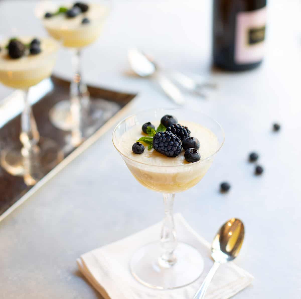 Champagne coupe glasses filled with Chilled Lemon Souffles, topped with blackberries and blueberries