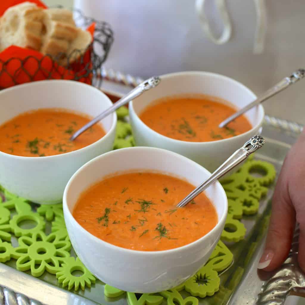 Three white bowls filled Chilled Tomato Dill Soup