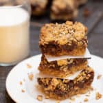 Stack of 3 Layered Oatmeal Chocolate Bars on a white plate, with a glass of milk