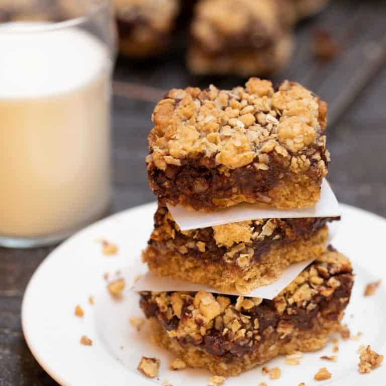 Stack of 3 Layered Oatmeal Chocolate Bars on a white plate, with a glass of milk