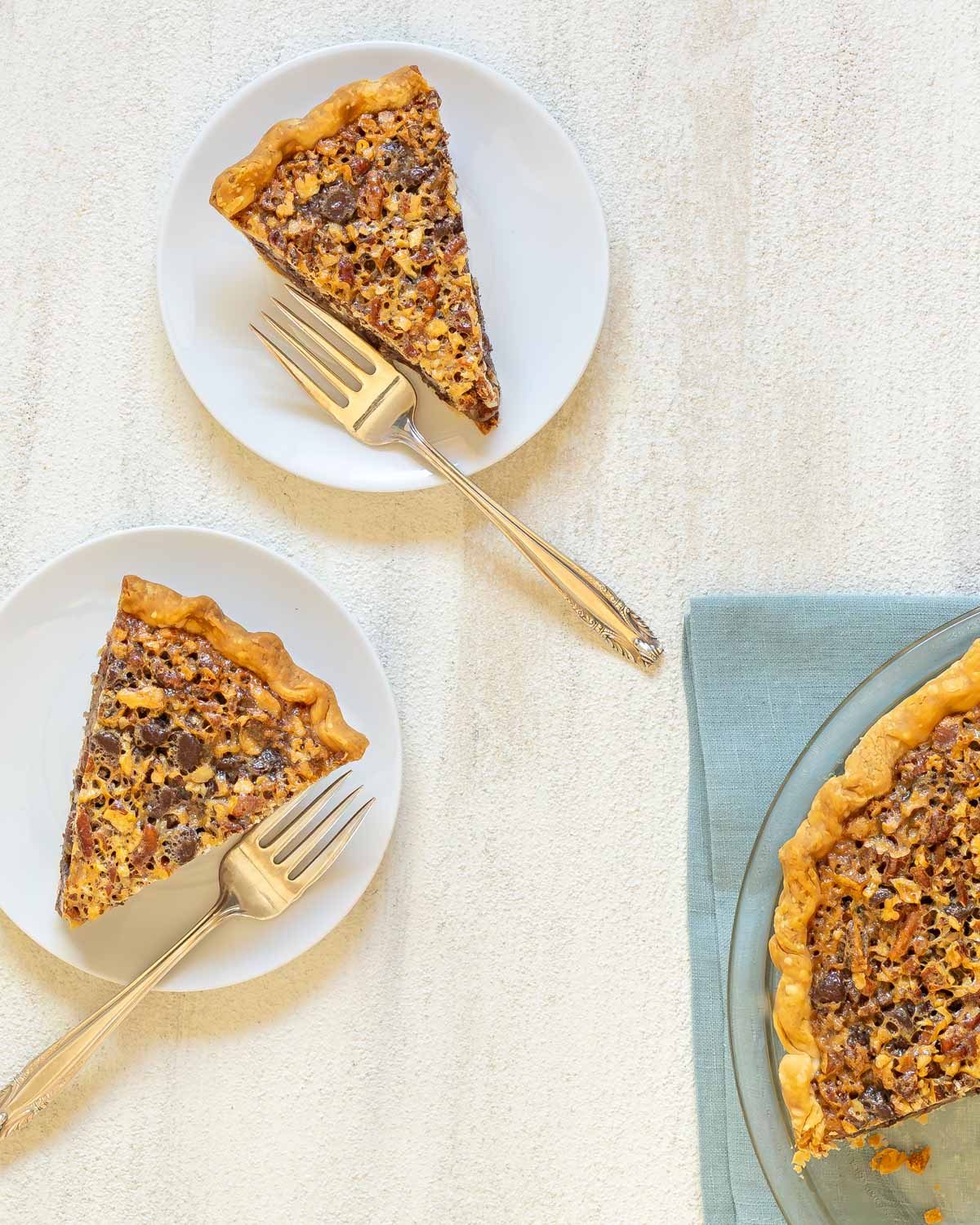 Homemade Chocolate Chip Pecan Pie has a flaky crust, luscious, gooey filling, and the perfect balance of sweet and nutty flavors. A delightful variation on the traditional pecan pie, its perfect for the holiday season. Try it today and experience the difference! #seasonedkitchen #pecanpierecipe #chocolatepecanpie #makeaheaddessert #holidayrecipes #homemade