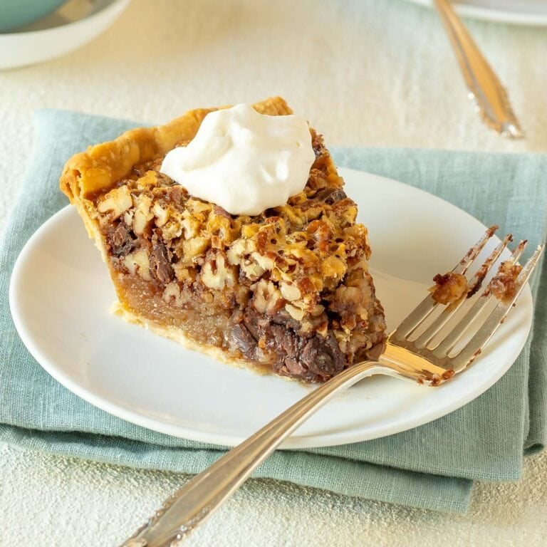 Single slice of Chocolate Pecan Pie topped with whipped cream