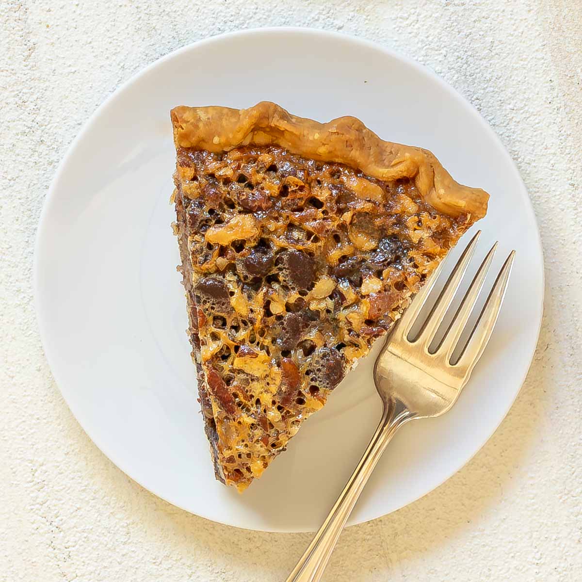 Overhead view of a single slice of Chocolate Chip Pecan PIe