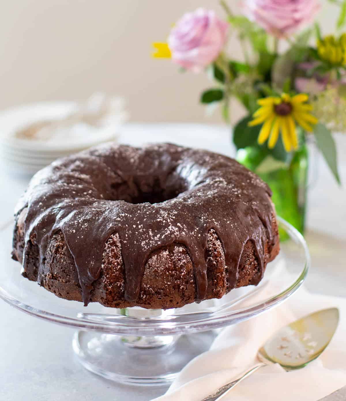 triple chocolate zucchini cake on a glass cake stand