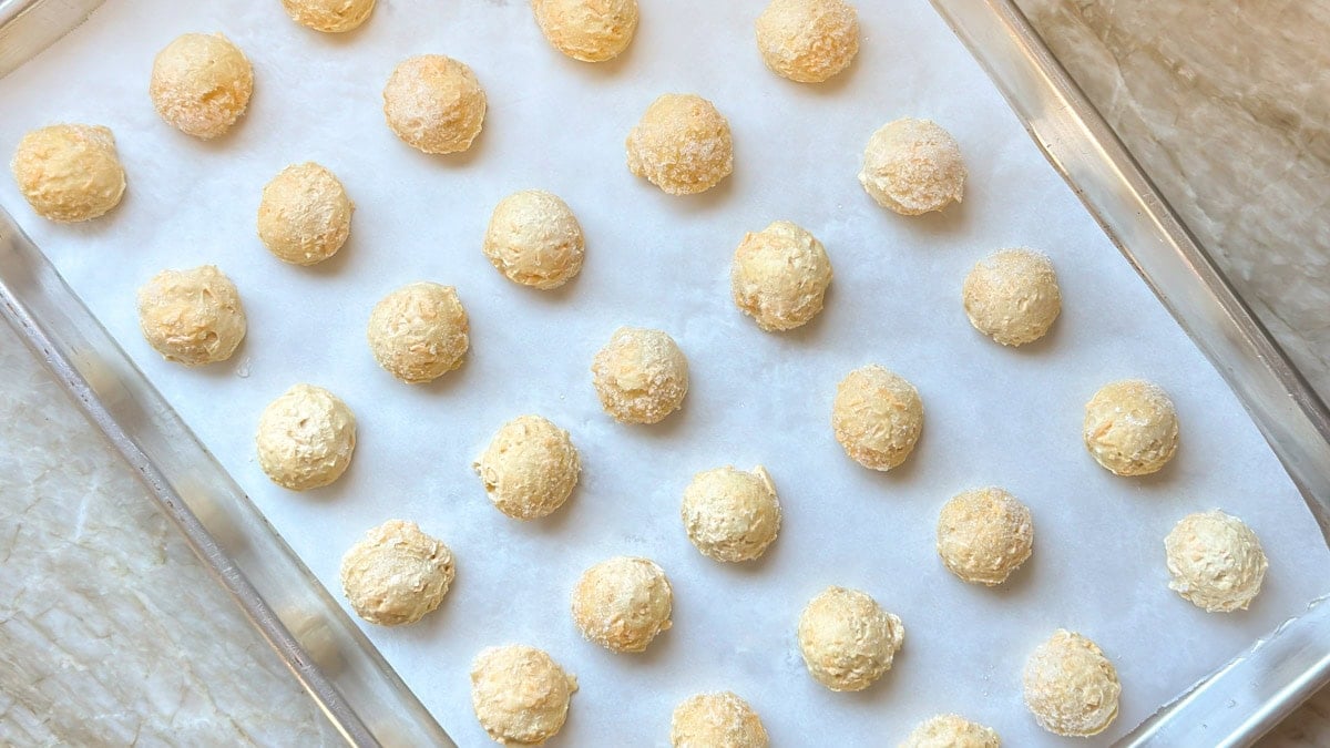 close up of cookie sheet holding scoops of raw choux pastry dough for gougères