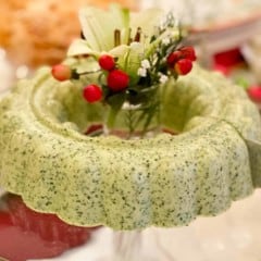 glass stand holding Cilantro Mousse ring filled with flowers