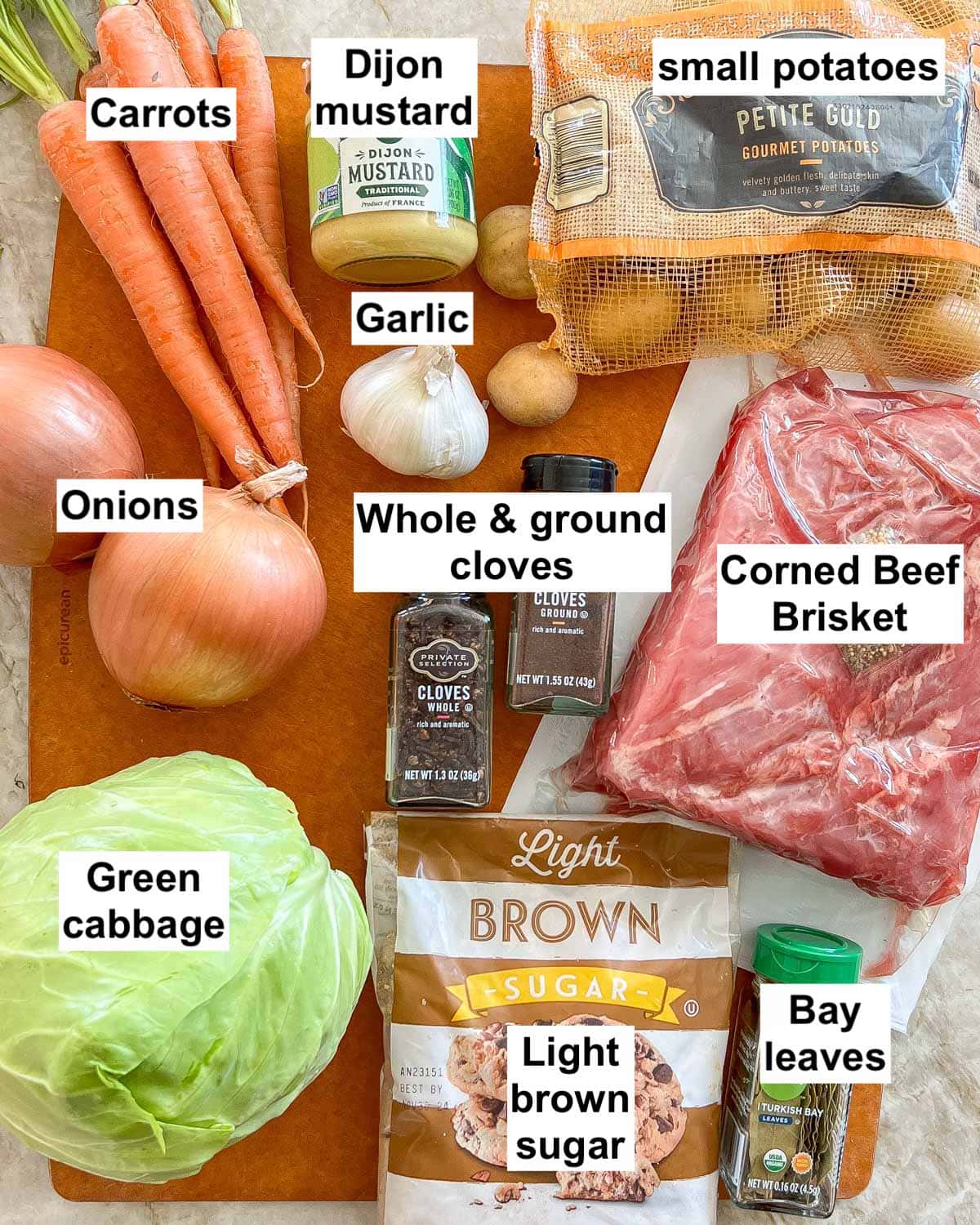 all 11 ingredients for Corned Beef and Cabbage with labels, on a cutting board