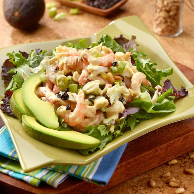 serving platter with Crab and Shrimp Salad atop mixed greens with sliced avocado alongside