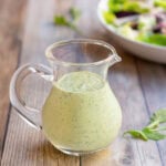 Glass pitcher holding creamy salad dressing recipe showing its smooth, creaminess.
