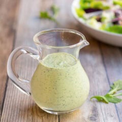 Glass pitcher holding creamy salad dressing recipe showing its smooth, creaminess.
