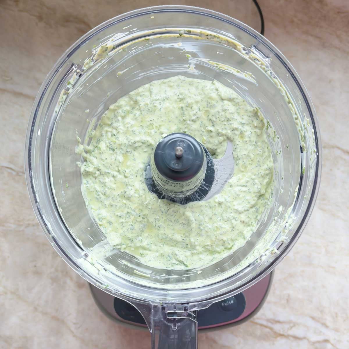 Food processor holding blended ingredients in this Creamy Salad Dressing recipe.