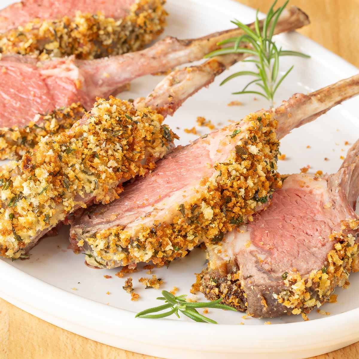 White platter holding individual chops from Crusted Rack of Lamb, showing crust detail