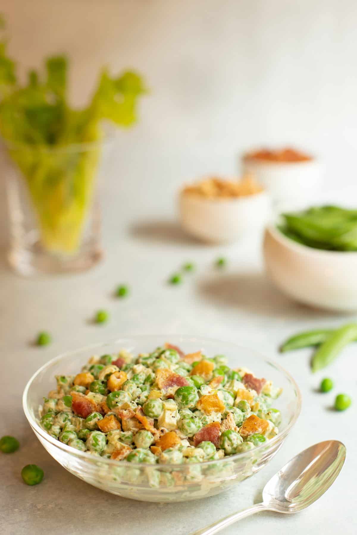 Glass bowl filled with Curried Pea Salad with Bacon and Cashews