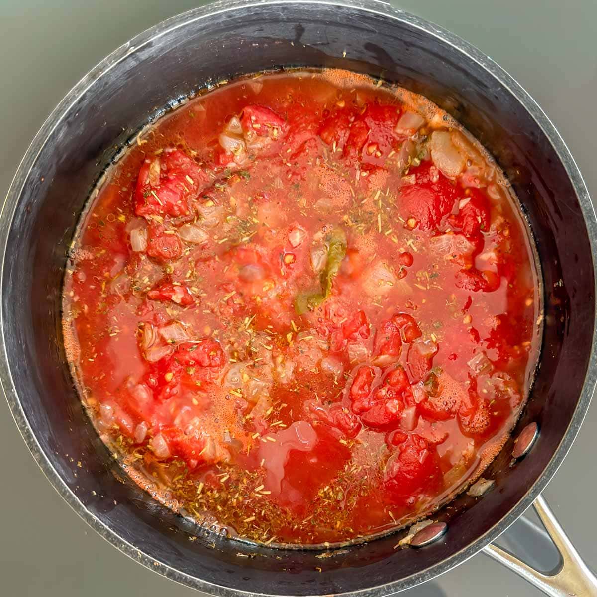 Marinara sauce in a saucepan showing texture before cooking or blending.