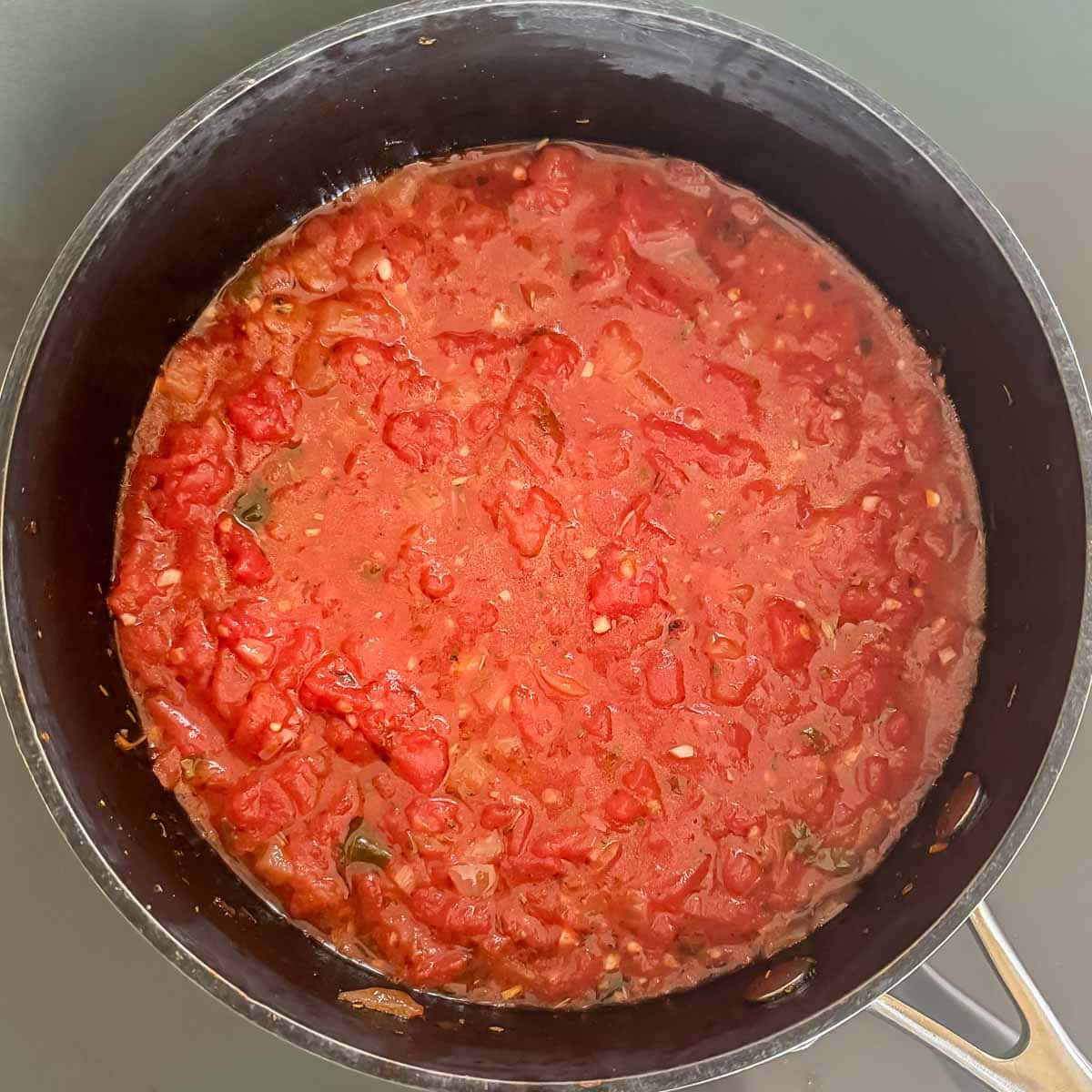 Marinara sauce in a saucepan showing texture after cooking but before blending.