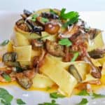 cooked eggplant and mushrooms tossed with wide pappardelle noodles, piled high.