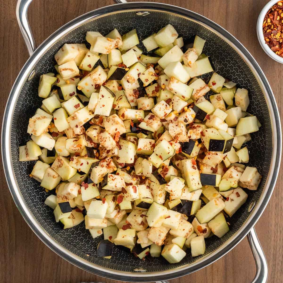 Chopped eggplant cooking in a pan.