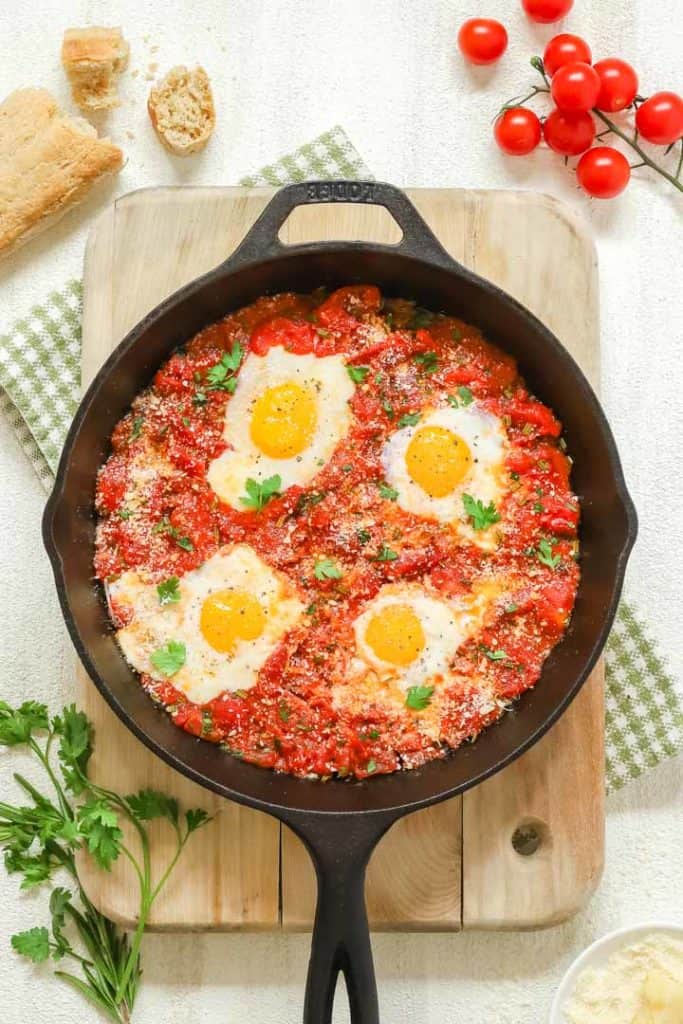 Overhead of cast iron skillet holding Poached Eggs in Italian Tomato Sauce