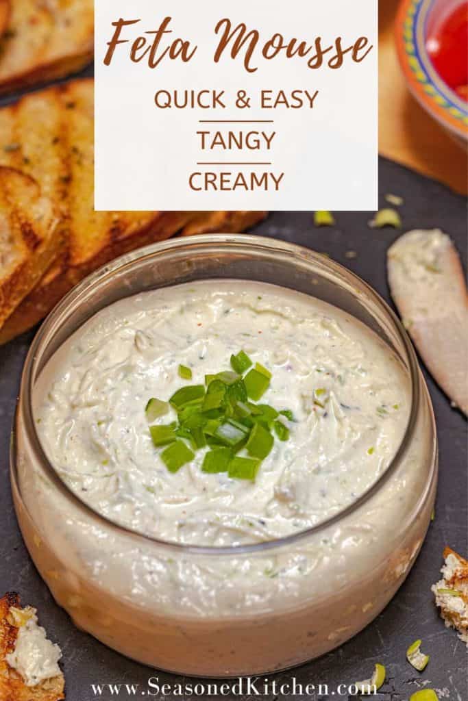 glass bowl illed with Feta Cheese Spread and garnished with chopped green onion, formatted for sharing on social media