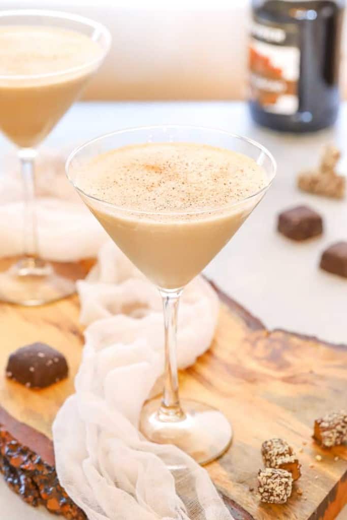 two martini glasses holding frozen brandy alexanders, with pieces of chocolate on the side 