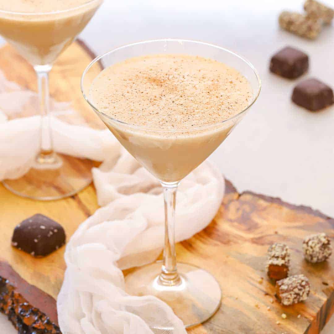 two martini glasses holding frozen brandy alexanders, with pieces of chocolate on the side 
