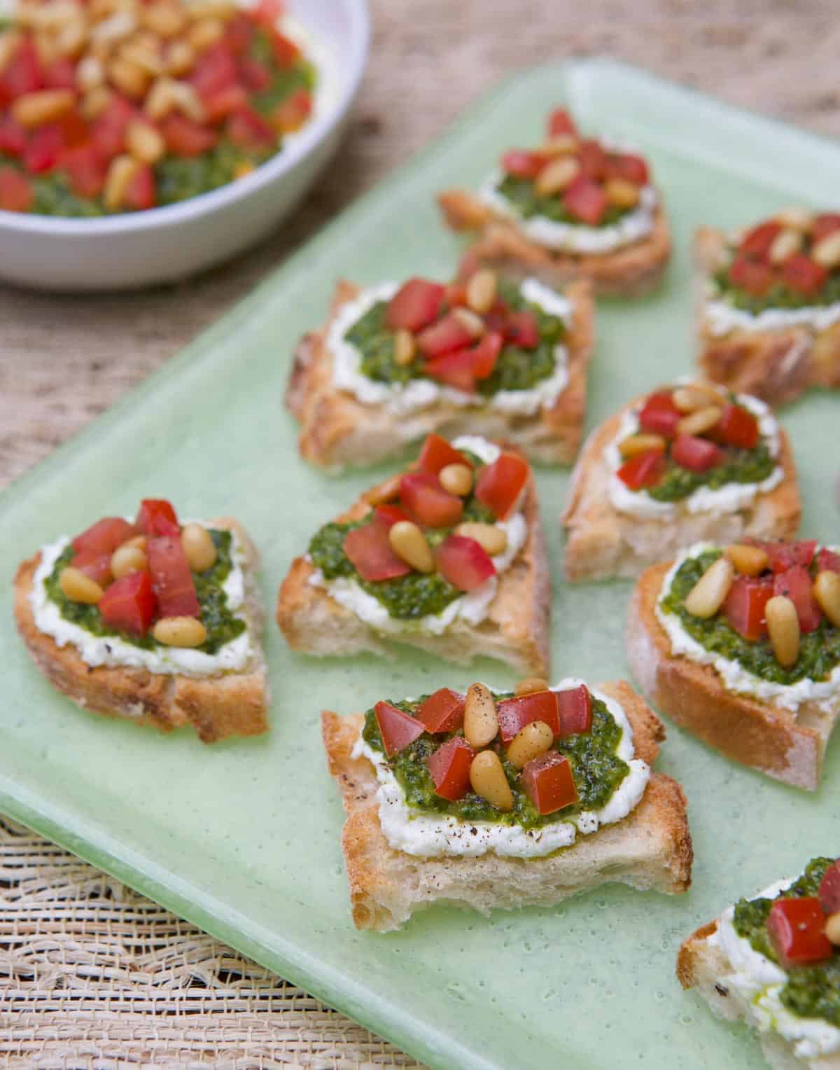 Light green platter with Goat Cheese, Pesto and Tomato Crostini