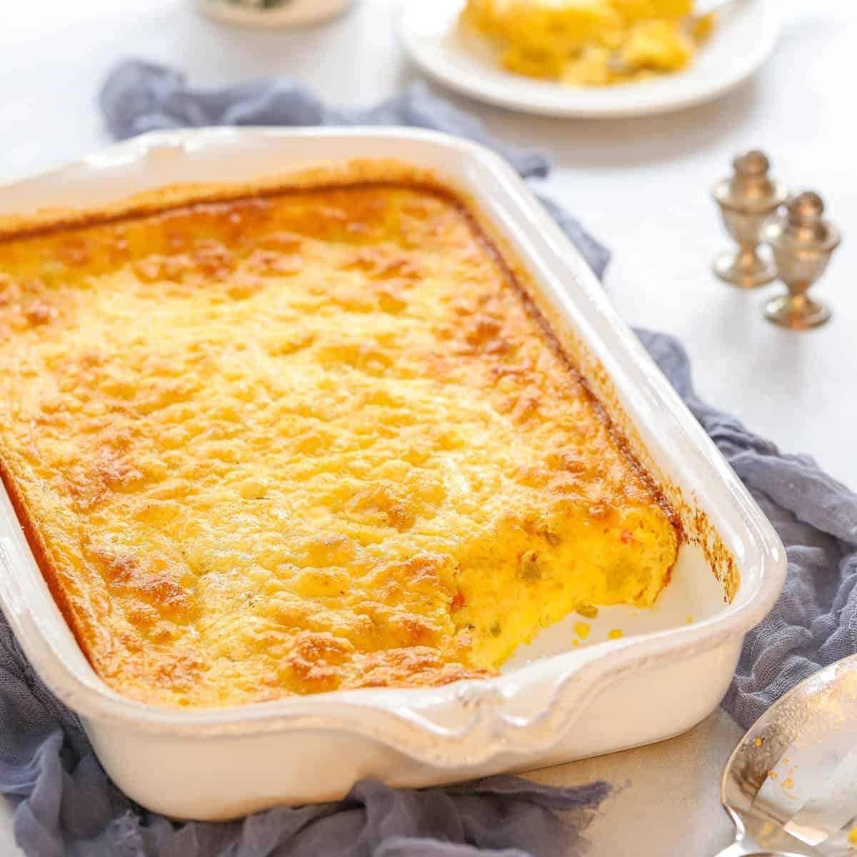 large baking dish holding Green Chile Breakfast Casserole with a portion removed to show the inside.