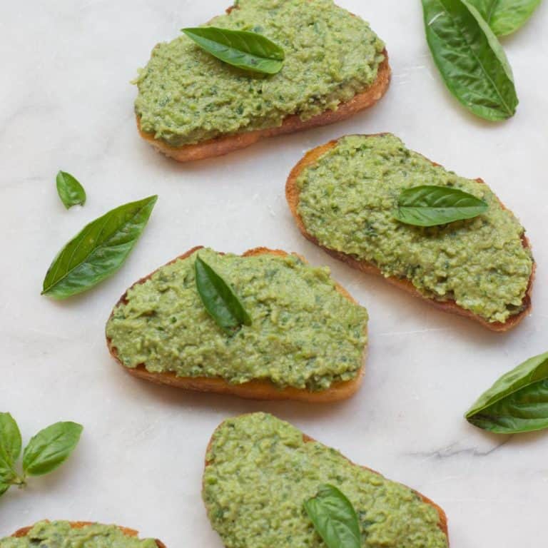 overhead shot of several green pea crostini, garnished with a mint leaf