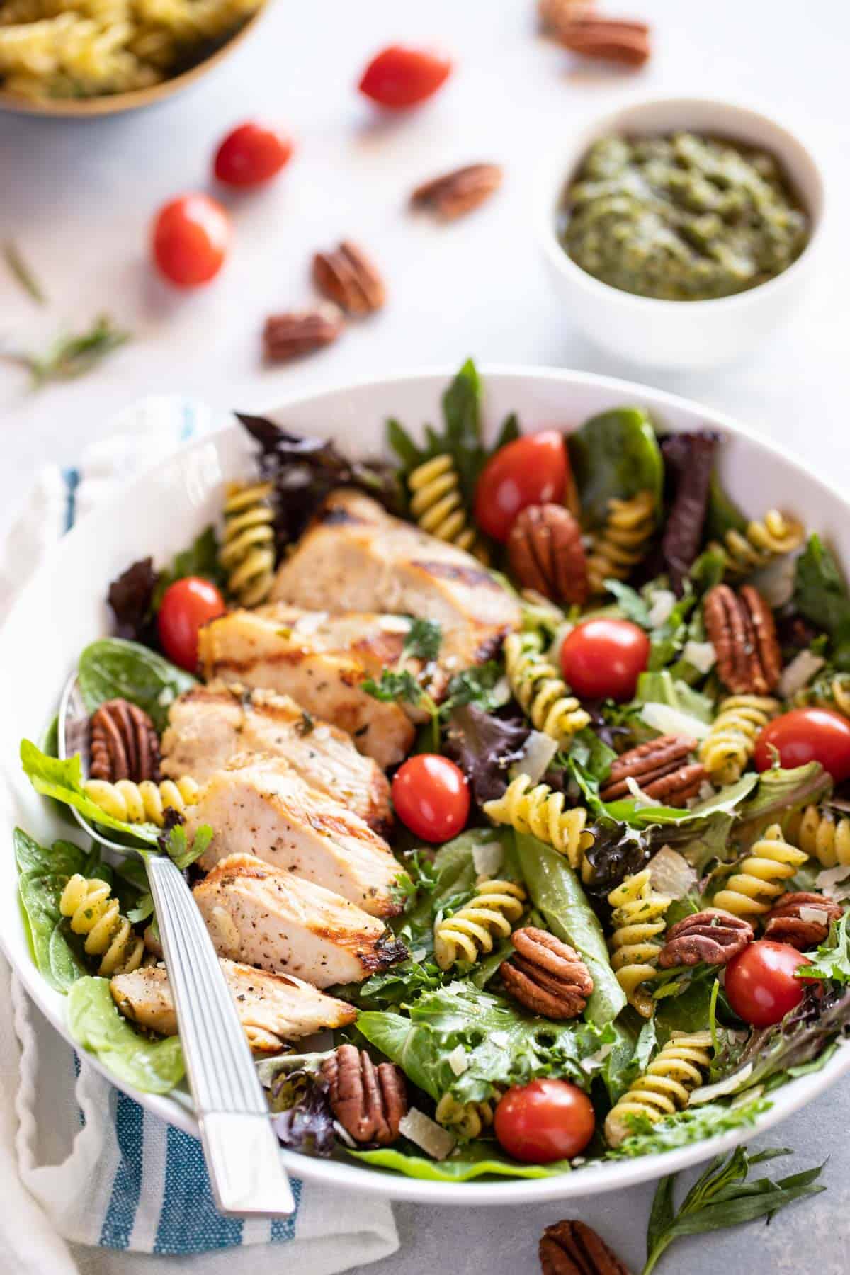 white bowl filled with Grilled Tarragon Chicken with Tomatoes, Pecans and Baby Spring Greens