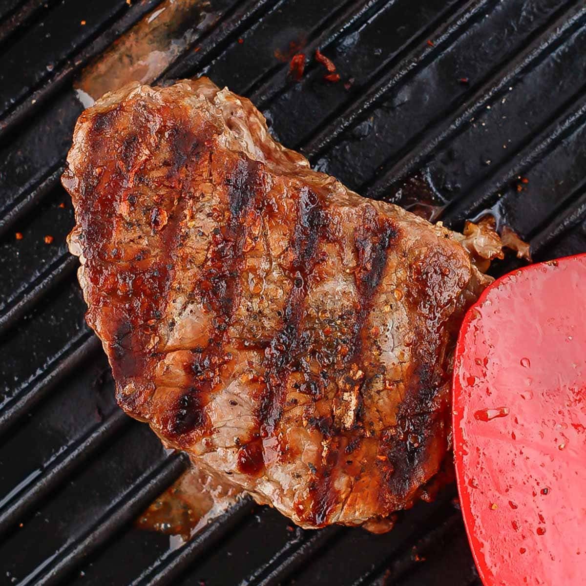 Grilled steak cooking on a grill.