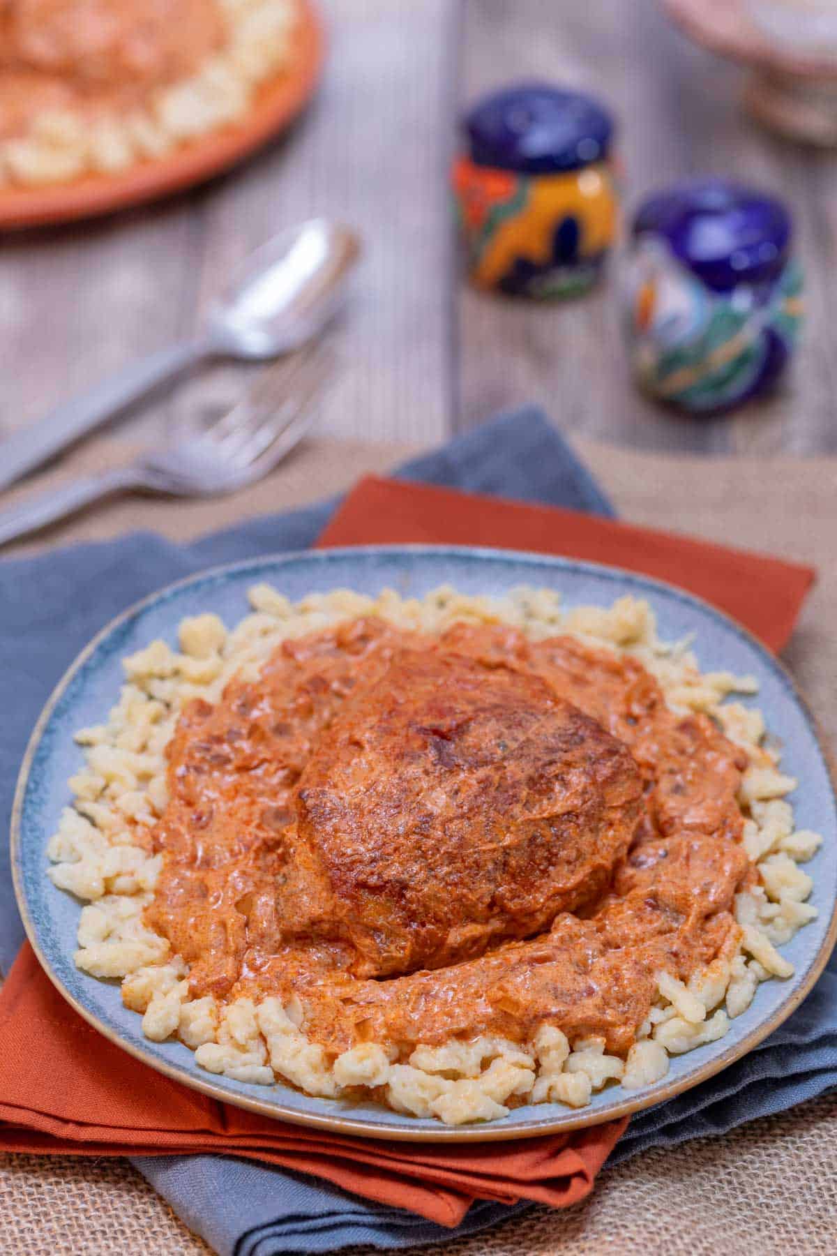 Blue plate showing a portion of Hungarian Chicken Paprikash