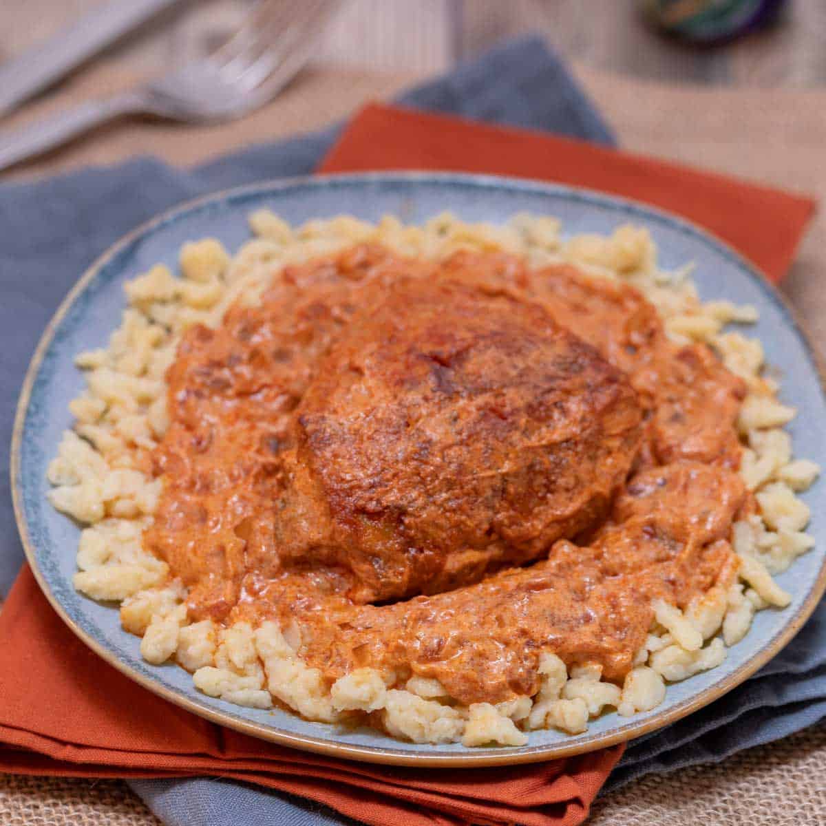 Close up of blue plate holding a portion of Chicken Paprikash