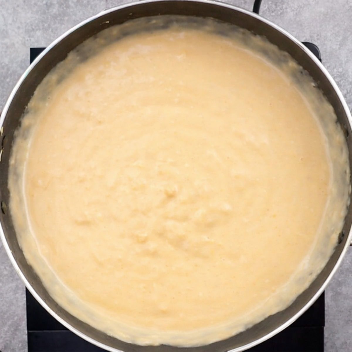 Finished mornay sauce showing thick creaminess and pale orange color.