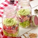 Large mason jars filled with Layered Salmon Salad With Avocado Dressing