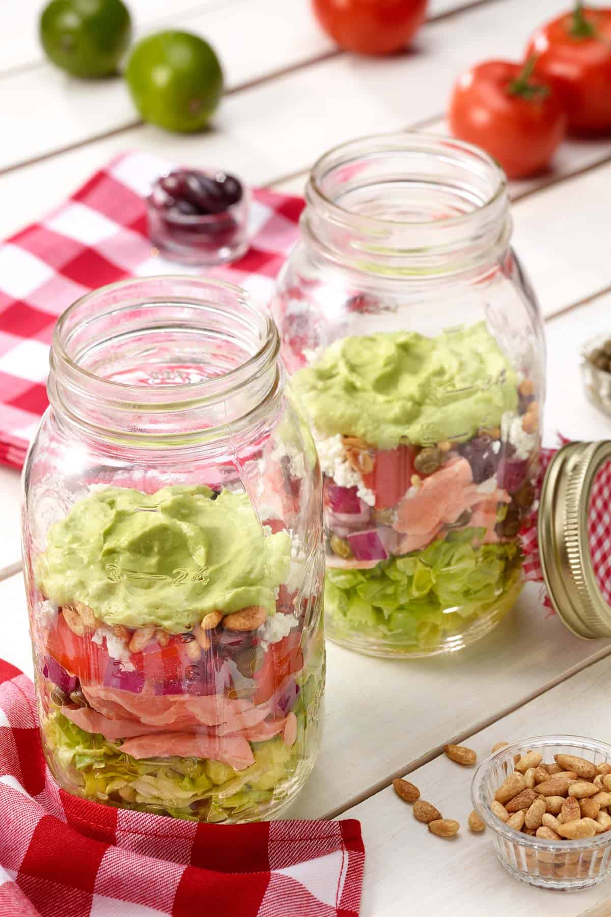 large mason jars filled with Layered Salmon Salad with Avocado Dressing