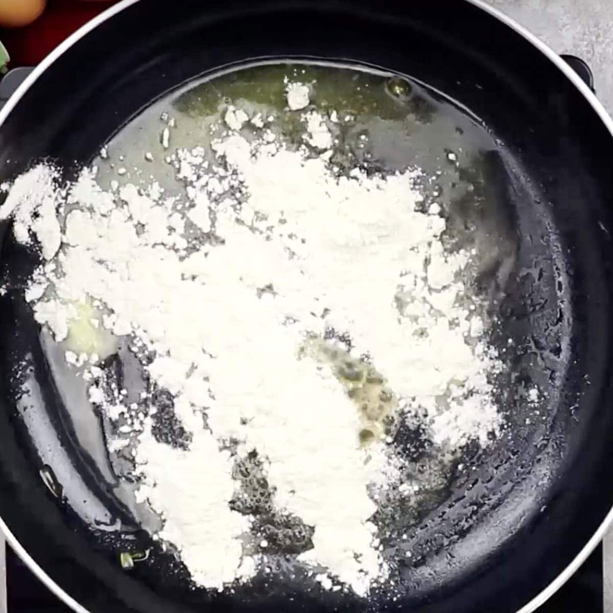 Flour added to the skillet of melted butter to make the roux.
