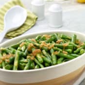 Oval white dish filled with Lemon-Dijon Green Beans with Caramelized Shallots