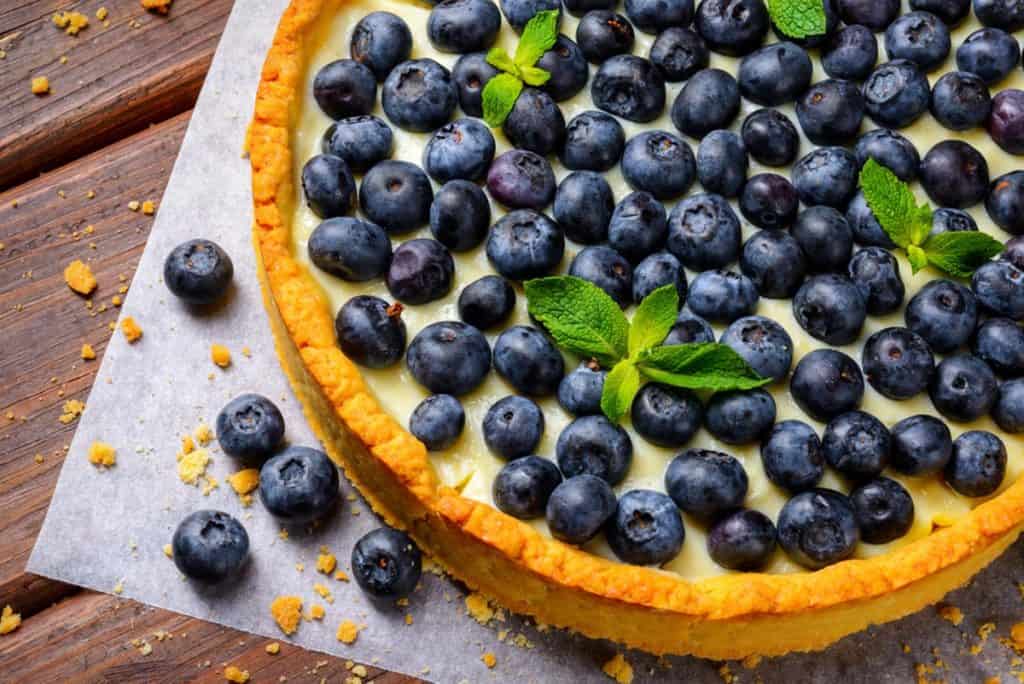 Gingersnap crusted tart filled with creamy lemony filing and topped with blueberries