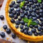 Gingersnap crusted tart filled with creamy lemony filing and topped with blueberries