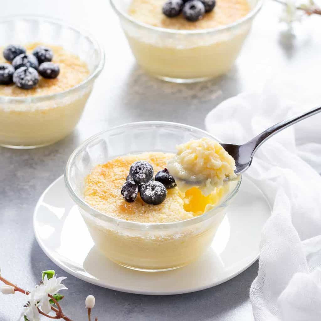 Individual Lemon Pudding Cup with a spoon showing a few of the inside