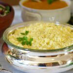 silver serving dish holding Lemon rice garnished with parsley.
